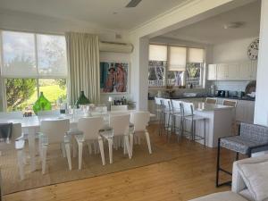 a kitchen and dining room with white tables and chairs at Beach Living at Its Best in McCracken