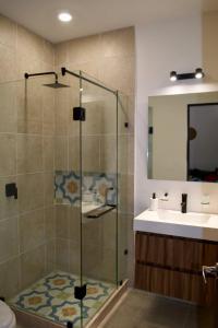 a bathroom with a glass shower and a sink at Encanto Department We Bill in Alcocer +22 photos
