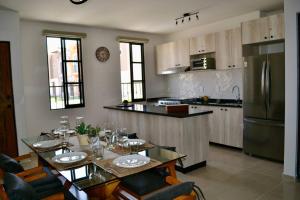a kitchen with a dining table and a refrigerator at Encanto Department We Bill in Alcocer