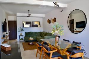 a living room with a table and a green couch at Encanto Department We Bill in Alcocer