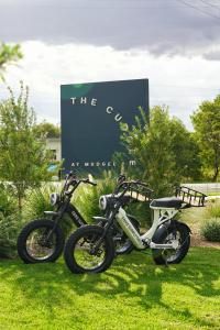 two motorcycles parked in the grass in front of a sign at The Cudgee at Mudgee in Mudgee