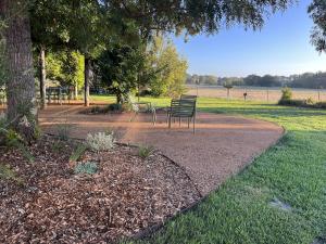 a park with two chairs sitting under a tree at The Cudgee at Mudgee in Mudgee +74 photos
