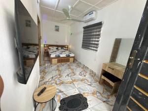 a room with two beds and a tiled floor at Jajoux Homes in Azohoué-Hiho