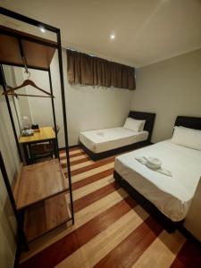 a small room with two beds and a mirror at Swing & Pillows - Dataran Nilai in Nilai
