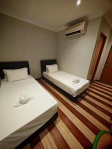 a room with two beds and a heater at Swing & Pillows - Dataran Nilai in Nilai