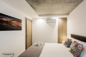 1 dormitorio con 1 cama blanca y una pintura en la pared en Innapartments - São Gonçalinho, en Aveiro