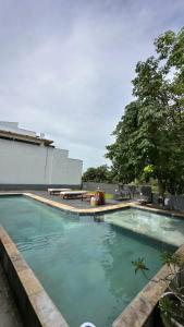 a swimming pool with blue water in front of a building at villa coqueiro praia do prea in Cruz