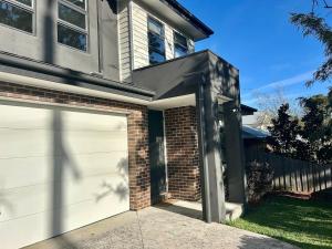 a garage door in front of a house at Modern Gem Steps from Everything You Need in Croydon North