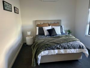 a bedroom with a large bed with pillows at Modern Gem Steps from Everything You Need in Croydon North