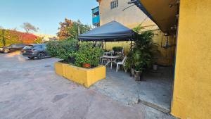 a table with a blue umbrella in a parking lot at Motel Olvera in Tijuana
