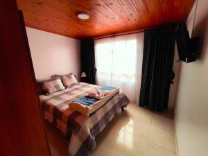a small bedroom with a bed and a window at Luma Dorada in Bogotá