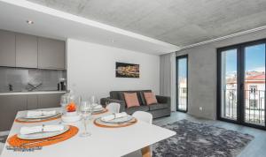 a kitchen and living room with a white table in a room at Innapartments - São Gonçalinho in Aveiro