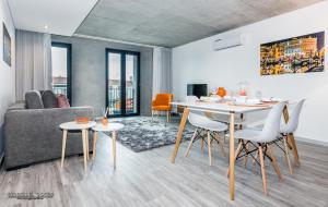 een woonkamer met een tafel en stoelen en een bank bij Innapartments - São Gonçalinho in Aveiro