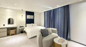a hotel room with a bed and a couch at 그루브 호텔 Groove Hotel in Jeonju