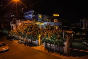a building with trees in front of it at night at Uniqato Hotel in Stara Zagora