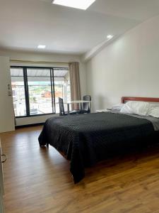 a bedroom with a bed and a large window at Mini Suites Cuarto Piso Alkimya in Loja