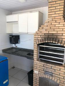 a kitchen with a brick fireplace in a room at Ap Turquesa in Teresina +16 photos