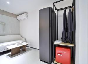 a small room with a bed and a red suitcase at 그루브 호텔 Groove Hotel in Jeonju +164 photos