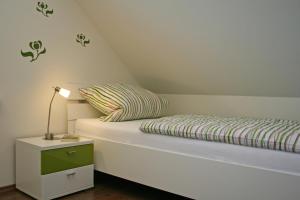 1 dormitorio con 1 cama con lámpara en una mesita de noche en Villa Harmonie W2, en Göhren-Lebbin