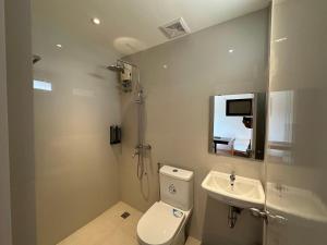a bathroom with a toilet and a sink and a mirror at Balay Inato Pension in Puerto Princesa City