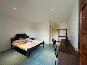 a bedroom with a bed and a desk with a computer at Balay Inato Pension in Puerto Princesa City