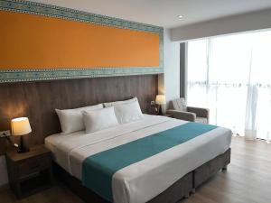a bedroom with a large bed and a large window at Hanaqua Cusco Hotel in Cusco