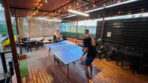 two men playing a game of tennis on a tennis court at Leveli Coliving & Hostel Oaxaca in Oaxaca City