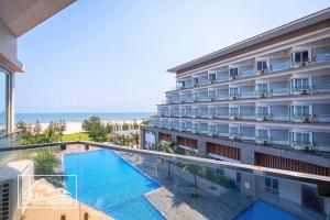 a hotel with a swimming pool and the beach at Duy Tân Quảng Bình Hotel & Resort in Dong Hoi