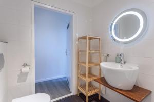 a bathroom with a white sink and a mirror at The Paul II - stylish & central 3 BR apartment, group & family friendly, 4- 6 Guests in Berlin