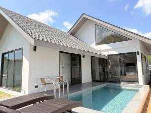 a villa with a swimming pool and a house at Akara Poolvilla Naithon Beach in Ban Sakhu