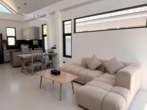 a living room with a couch and a table at Akara Poolvilla Naithon Beach in Ban Sakhu
