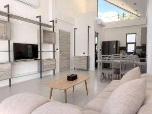 a living room with a couch and a table at Akara Poolvilla Naithon Beach in Ban Sakhu