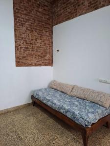 a bed in a room with a brick wall at De Paso Pergamino in Pergamino