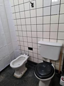 a bathroom with a toilet and a bidet at De Paso Pergamino in Pergamino