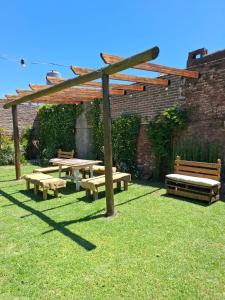 a picnic table and benches in a yard at De Paso Pergamino in Pergamino