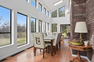 a dining room with a table and chairs and windows at Summit Sanctuary with EV Ready Mountain Views in Poughkeepsie