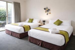 two beds in a hotel room with a window at De'Vine Escape in Dixons Creek