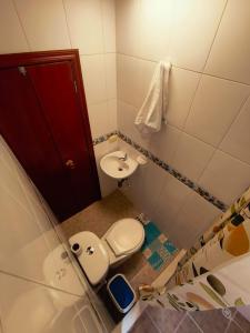 a small bathroom with a toilet and a sink at Luma Dorada in Bogotá
