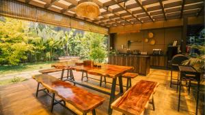 a dining room with wooden tables and benches at Vanantara Riverside Eco Retreat in Cochin