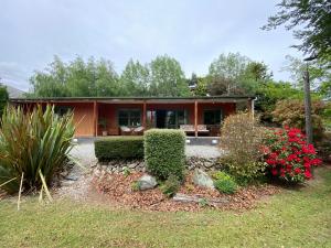 a house with bushes and flowers in front of it at Omarama township location - how good! in Omarama