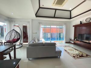 a living room with a couch and a table at The Sun Pool Villa in Chaweng