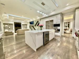 a large kitchen with white cabinets and a living room at Modern Luxury Living in Toronto