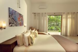 a bedroom with a bed with pillows and a window at The Glasshouse Victoria in Digana +28 photos