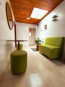 a living room with a green couch and a table at Luma Dorada in Bogotá +1 photo