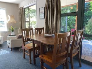 a dining room with a wooden table and chairs at Omarama township location - how good! in Omarama +6 photos