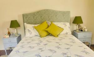 a bedroom with a bed with yellow pillows and two night stands at The Secret Garden Burradoo in Burradoo