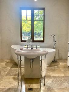 a bathroom with a sink and a tub and a window at The Secret Garden Burradoo in Burradoo +18 photos
