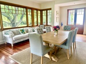 a living room with a wooden table and chairs at The Secret Garden Burradoo in Burradoo