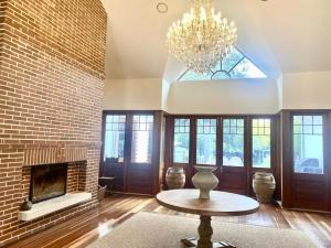 a living room with a fireplace and a chandelier at The Secret Garden Burradoo in Burradoo