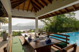 a table and chairs on a patio with a pool at The Glasshouse Victoria in Digana